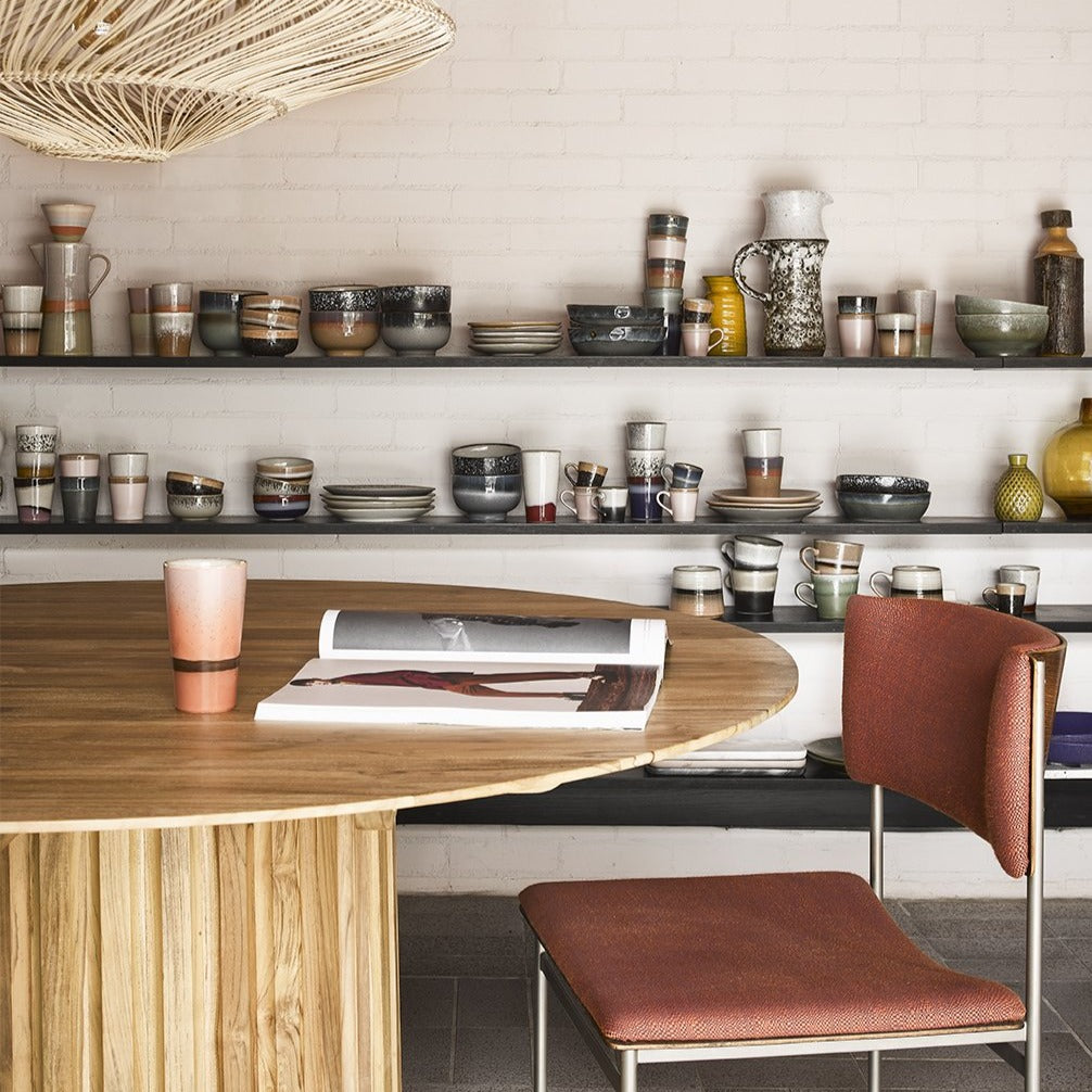detail of round teak wood table with retro chair