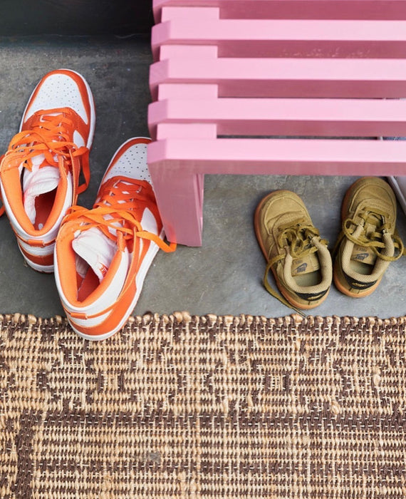 hallway bench with sneakers and a pink slatted bench