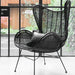 black RATTAN EGG CHAIR IN FRONT OF A WINDOW