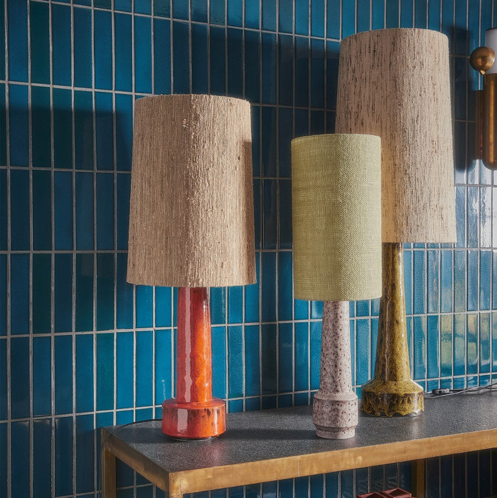 tree retro style table lamps on a console table against a blue tiled wall