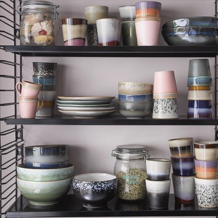 open shelving with retro style stoneware cups mugs and saucers and bowls
