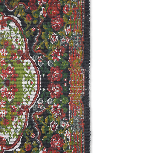 detail of printed rug with rose pattern and black trim