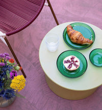 green stoneware side table with green glass bowl with fruit