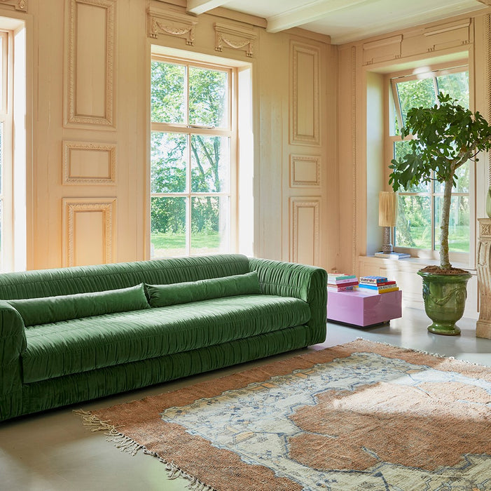 large green velvet sofa and square area rug 