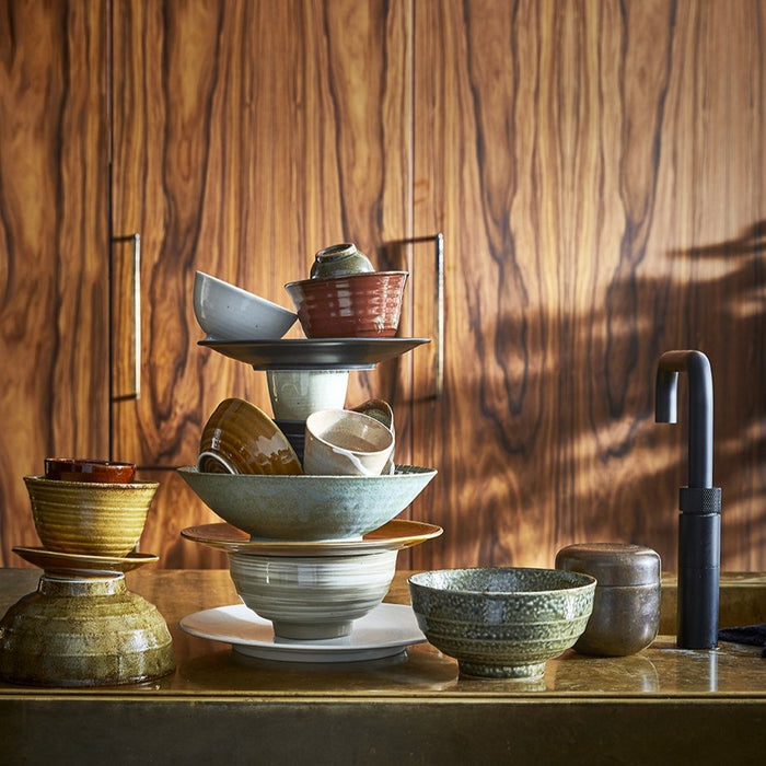 kitchen with wooden cabinets and a stack of HK living Kyoto ceramics in earth tones