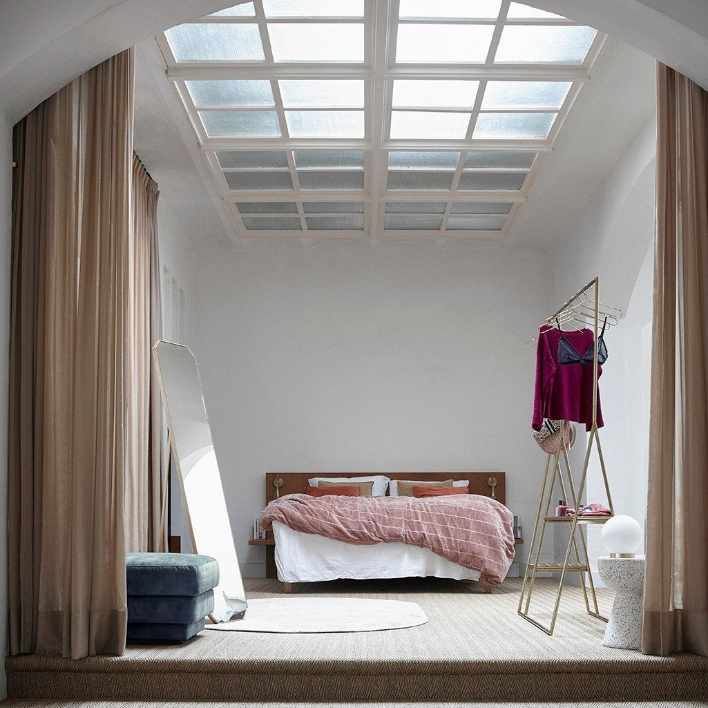 bedroom with tall standing mirror, open wardrobe and blue velvet hocker