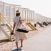 lady walking on beach with striped beach tote
