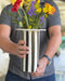 white vase with black vertical stripes and purple red and yellow flowers