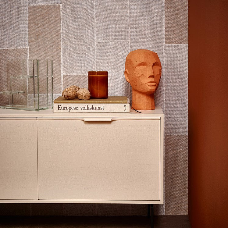 orange head sculpture on a sideboard
