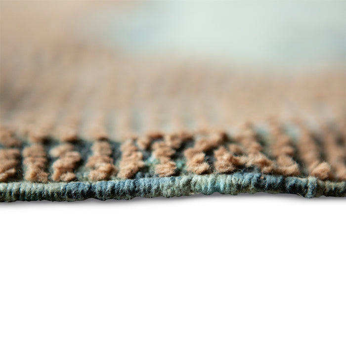 detail of square area rug with fringes and muted colors