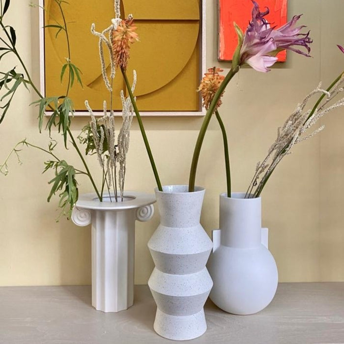 angular shaped vase next to a Greek inspired vase