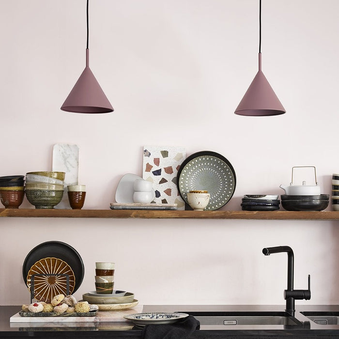 kitchen with open shelving and two metal triangle pendant lights in a blush color next to eachother