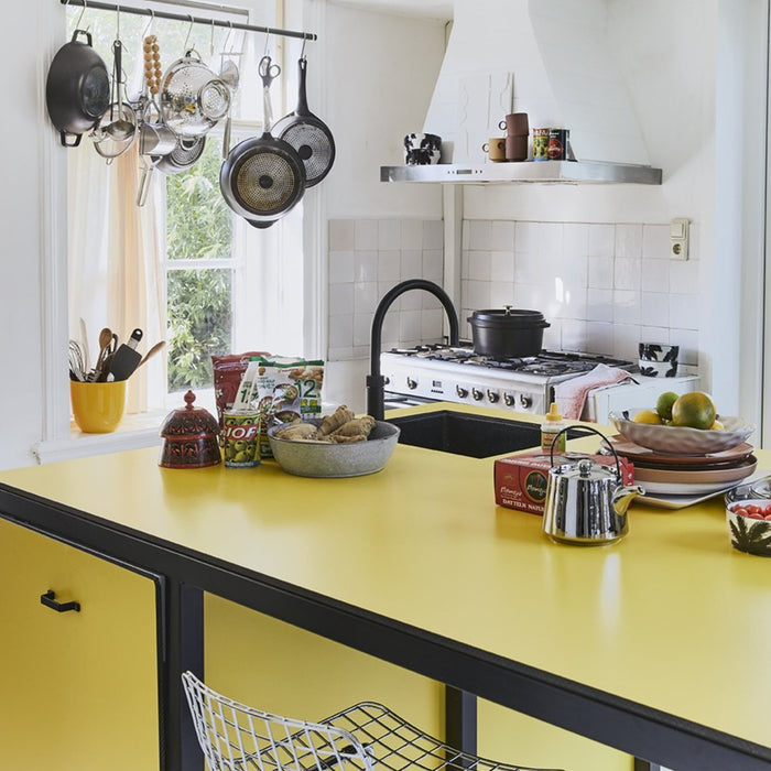 kitchen with yellow countertop and art panel on hood