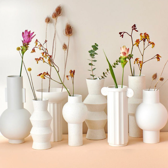 group of white clay vases with spring flowers