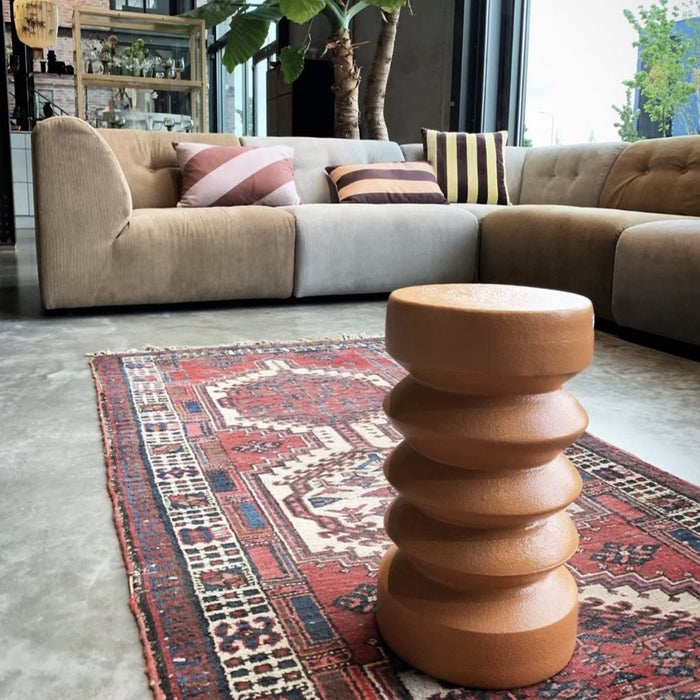 small terracotta side table in a living room with large sofa