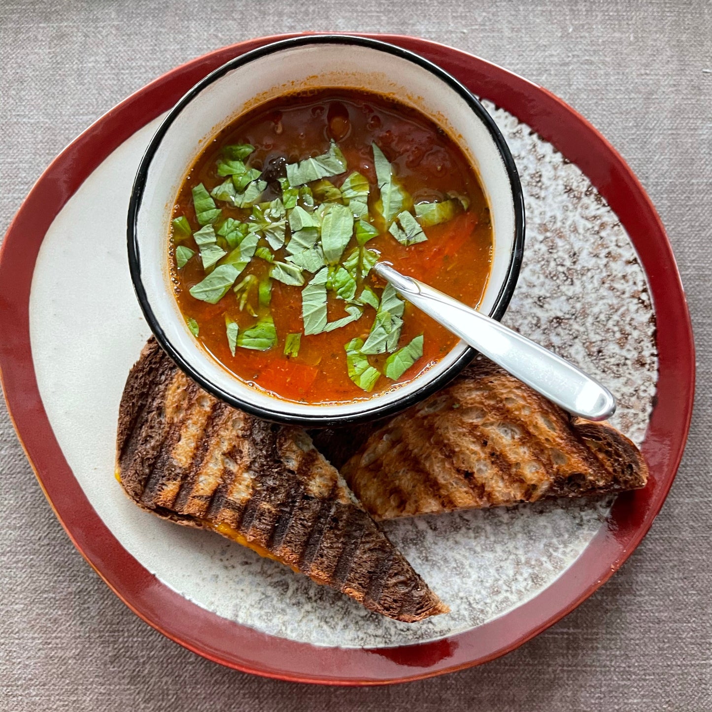 organic shaped dinner plate frost by HKliving USA with a bowl of tomato soup and grilled cheese