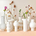 group of white speckled clay vases with spring flowers