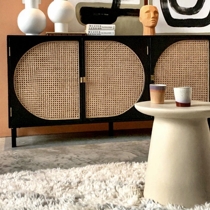 earthenware side table with a black sideboard with cane webbing doors