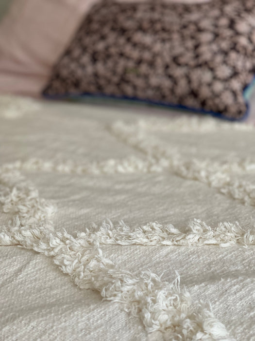 close up of textured natural linen bedspread with fringes