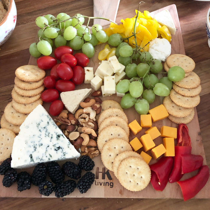 charcuterie plate with crackers, cheese, grapes and tomato's