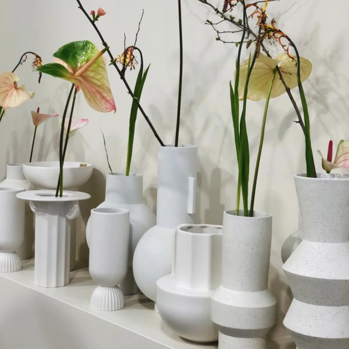 combination of white stoneware vases in various shapes and heights 