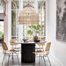 black pillar dining table with large wicker pendant and 4 natural rattan dining chairs