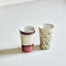 two ceramic tea mugs in cream, cerise and black colors