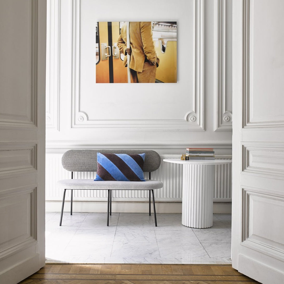 hallway with white pillar side table and grey fabric bench in two colors