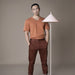 guy with orange shirt next to a floor lamp with triangle shaded hood
