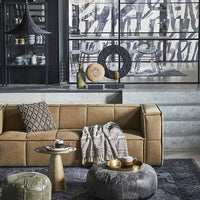 khaki brown couch and leather poufs with brown throw blanket in living room